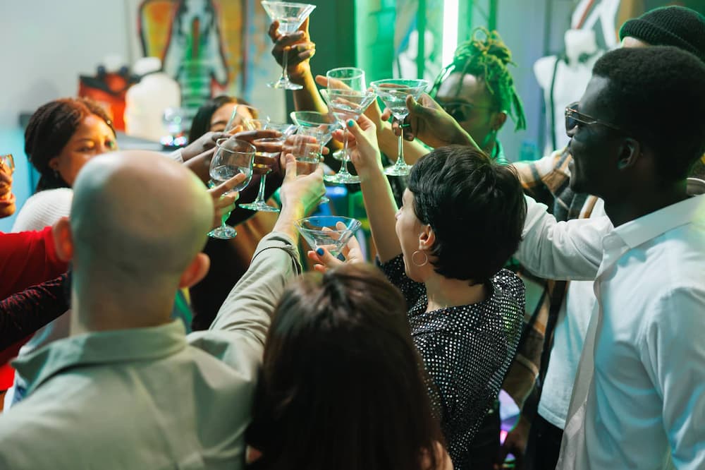 A group of people toasting with cocktails in a festive setting.