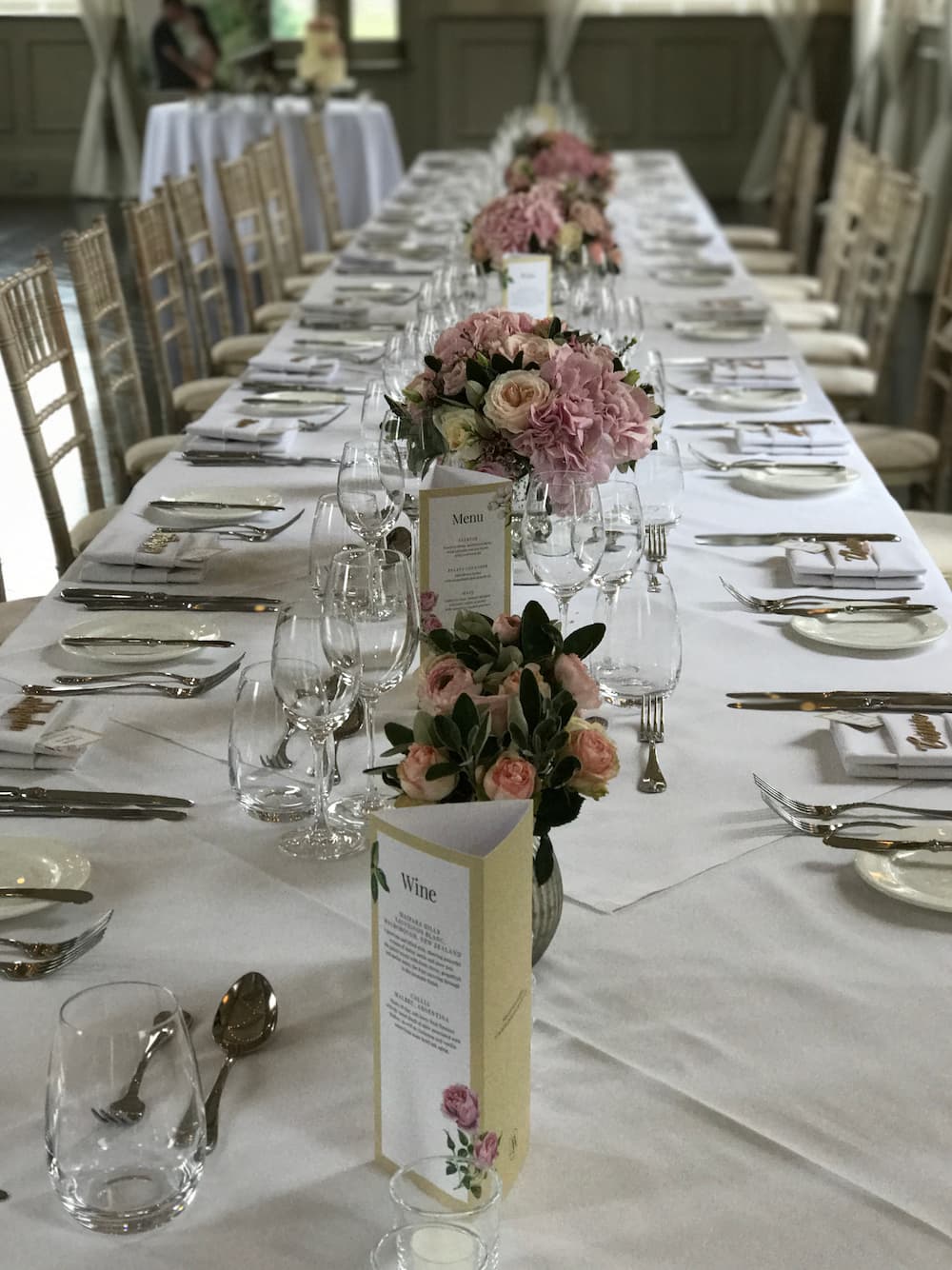long wedding table with cutlery and floral arrangements